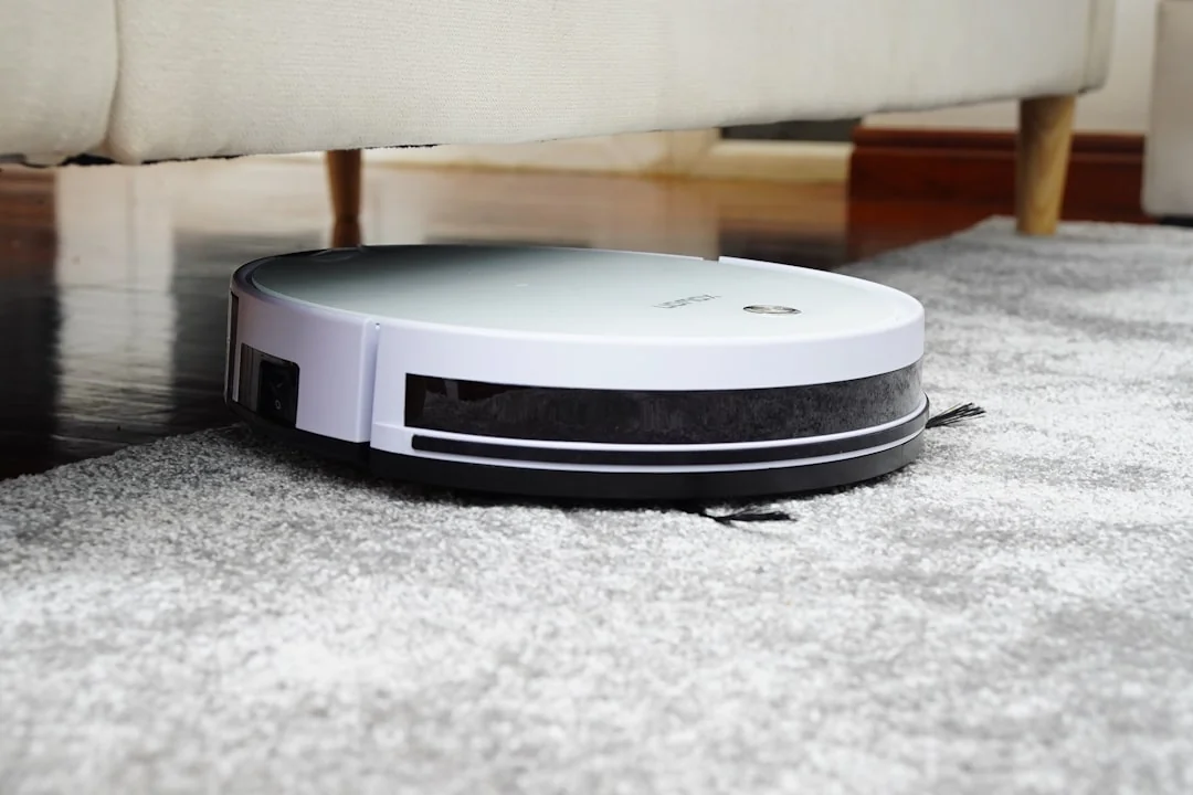 A professional cleaner in protective gear vacuuming the floor in a modern living room.